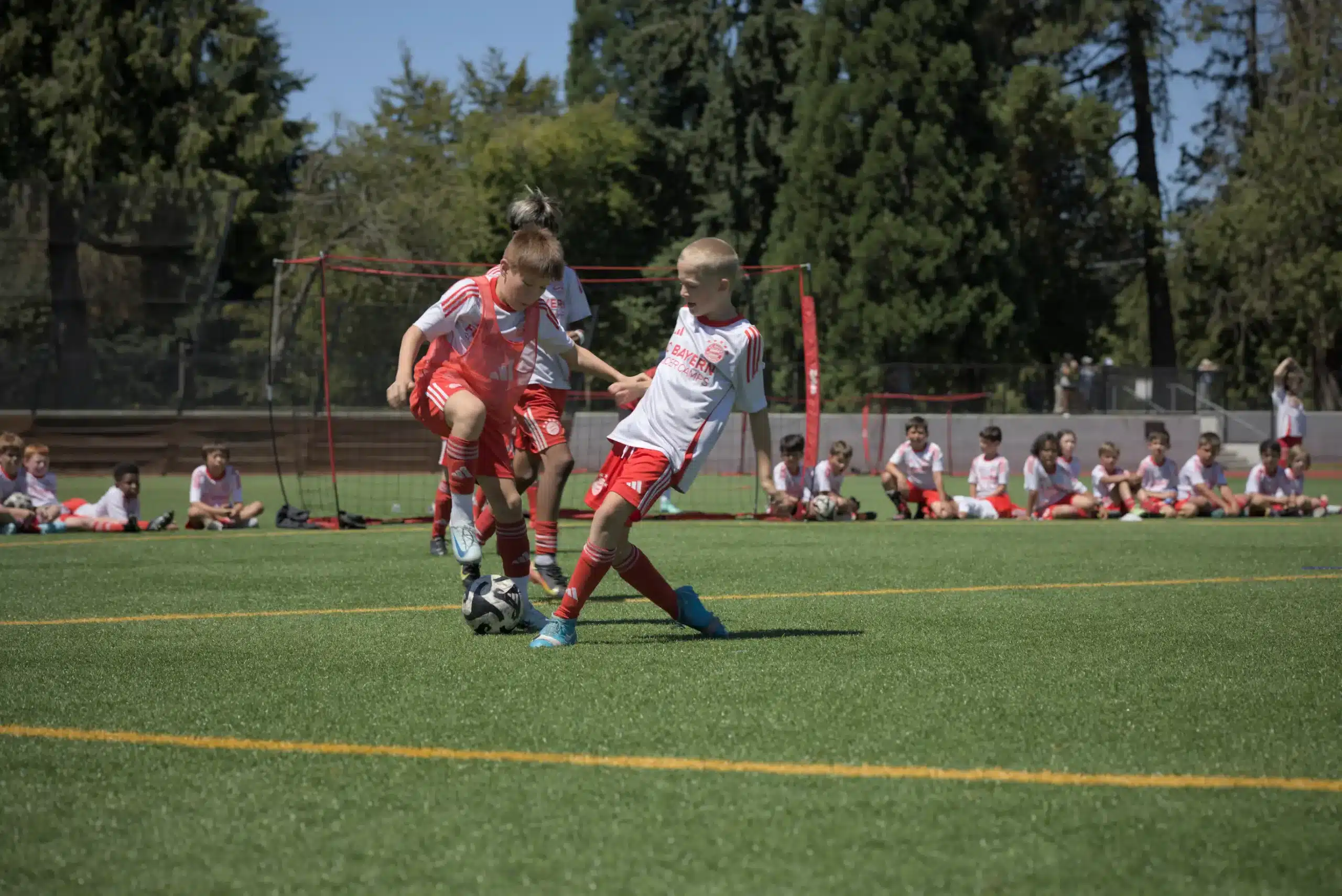 A young player answers the question, "What does a defender do in soccer?" by successfully executing a tackle during an FC Bayern Academy training session.